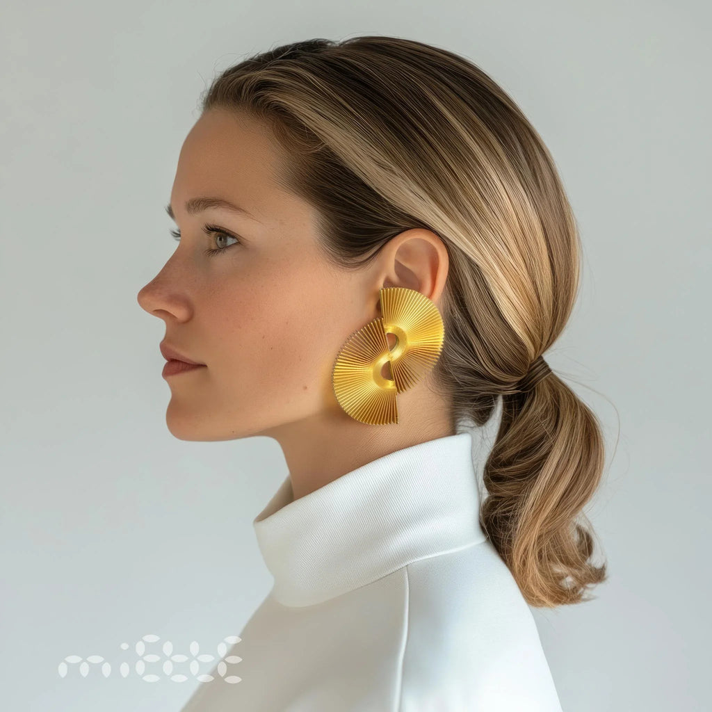 Woman wearing large gold statement earring, side profile, white turtleneck, minimalist style