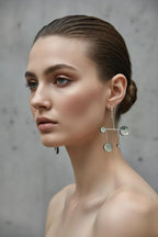 Woman wearing modern geometric silver statement earrings, minimalist jewelry look