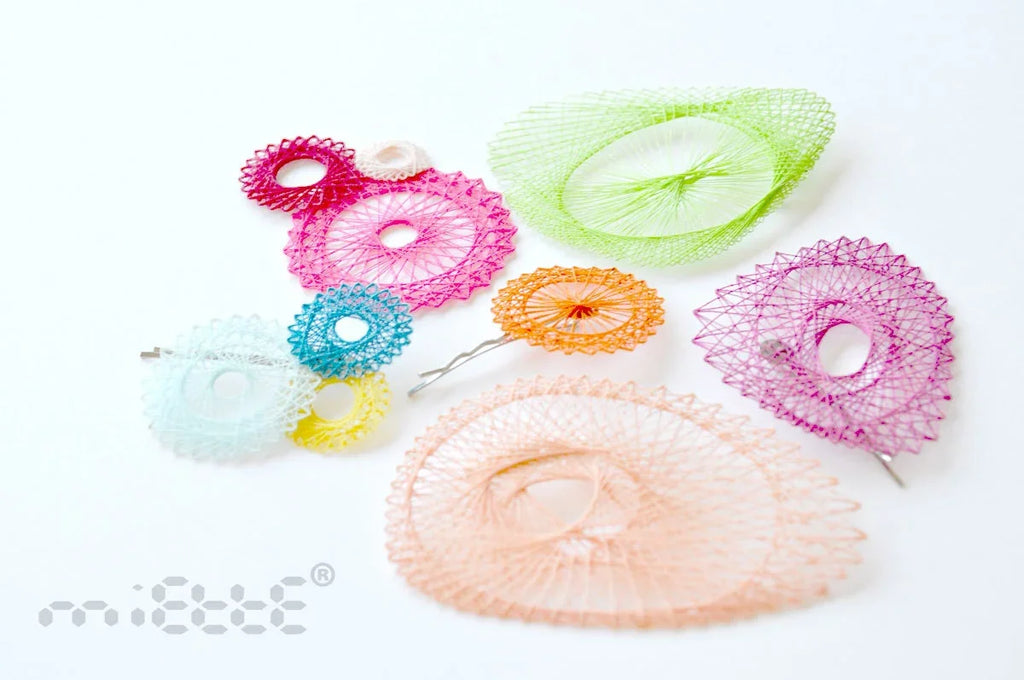 Colorful geometric mesh hair clips and brooches arranged on a white background