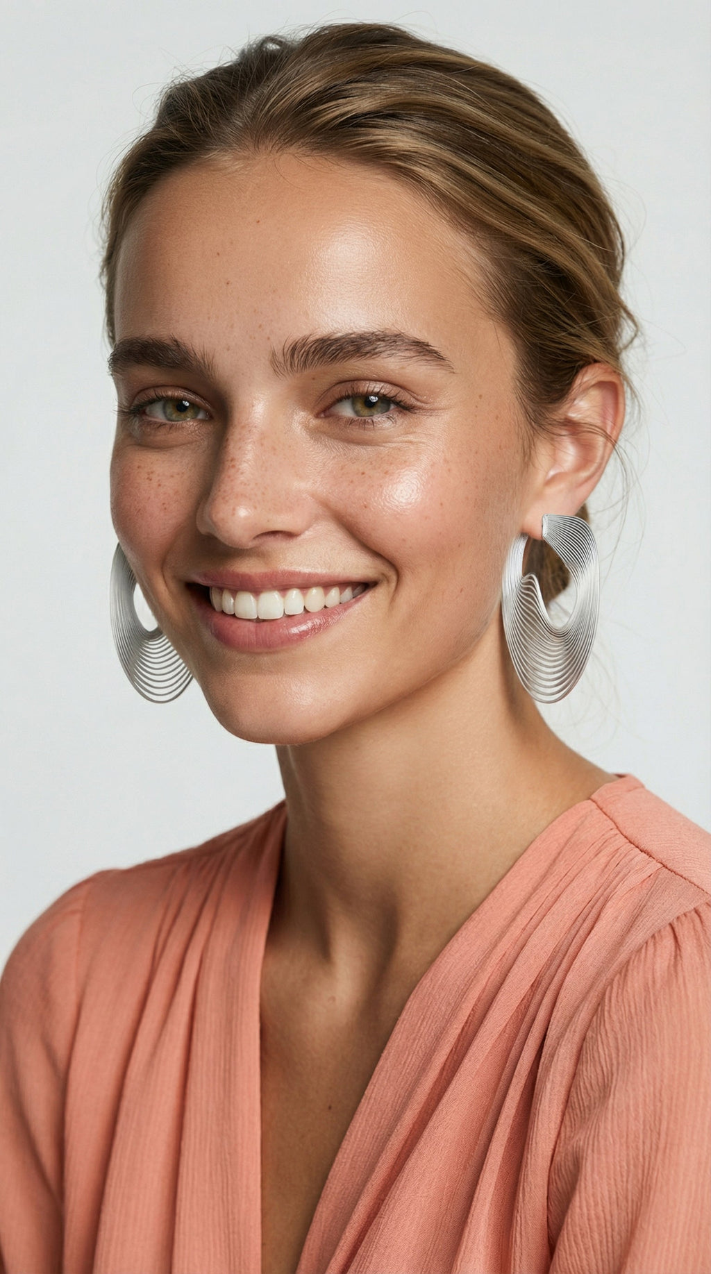 Women wearing large metallic optical art earrings