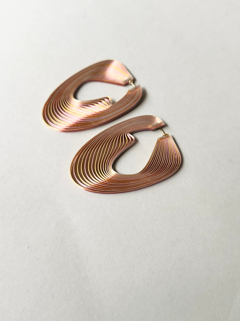 Close-up of pink metallic optical art earrings